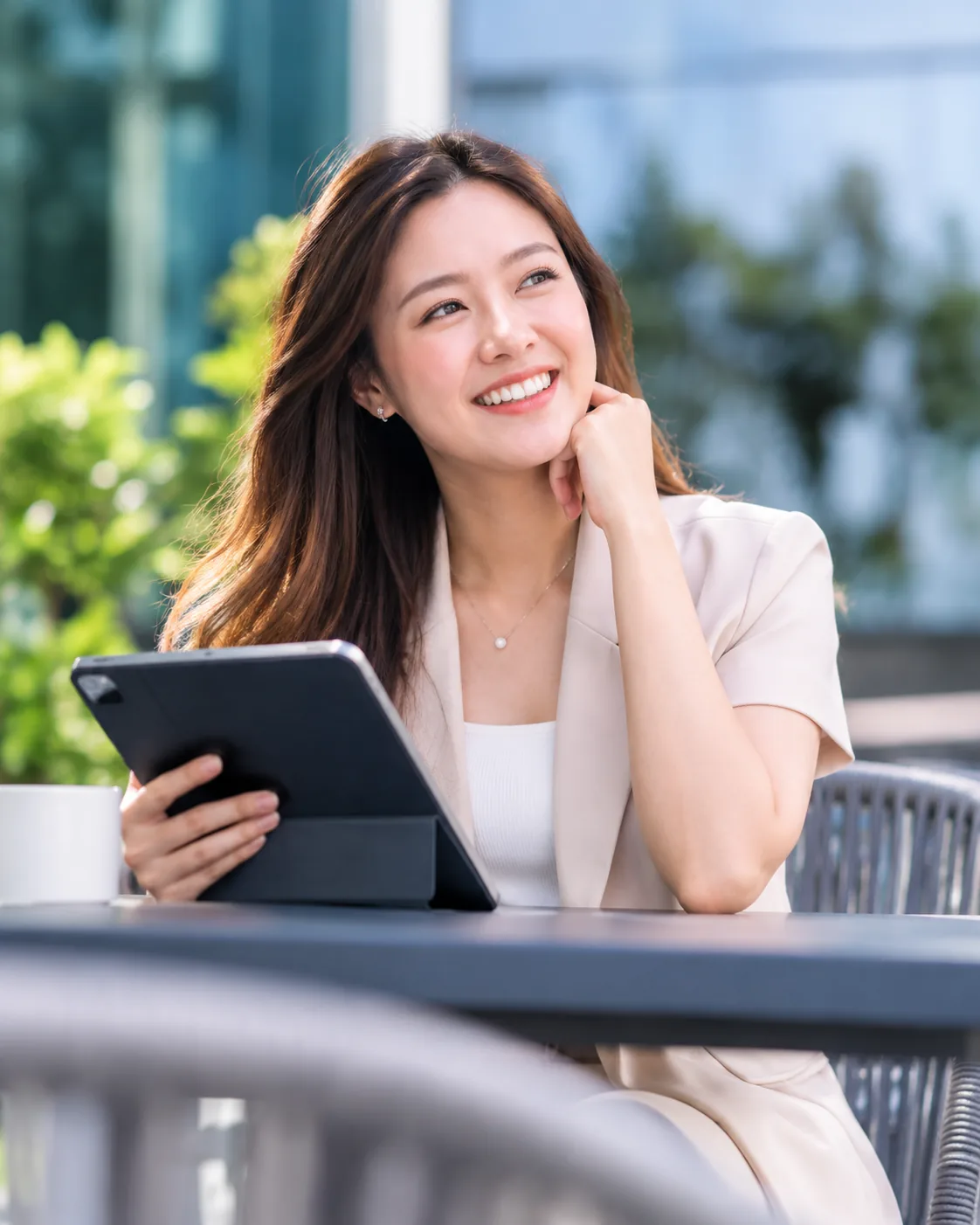Our Service Commitments Professional holding a tablet while seated outdoors.
